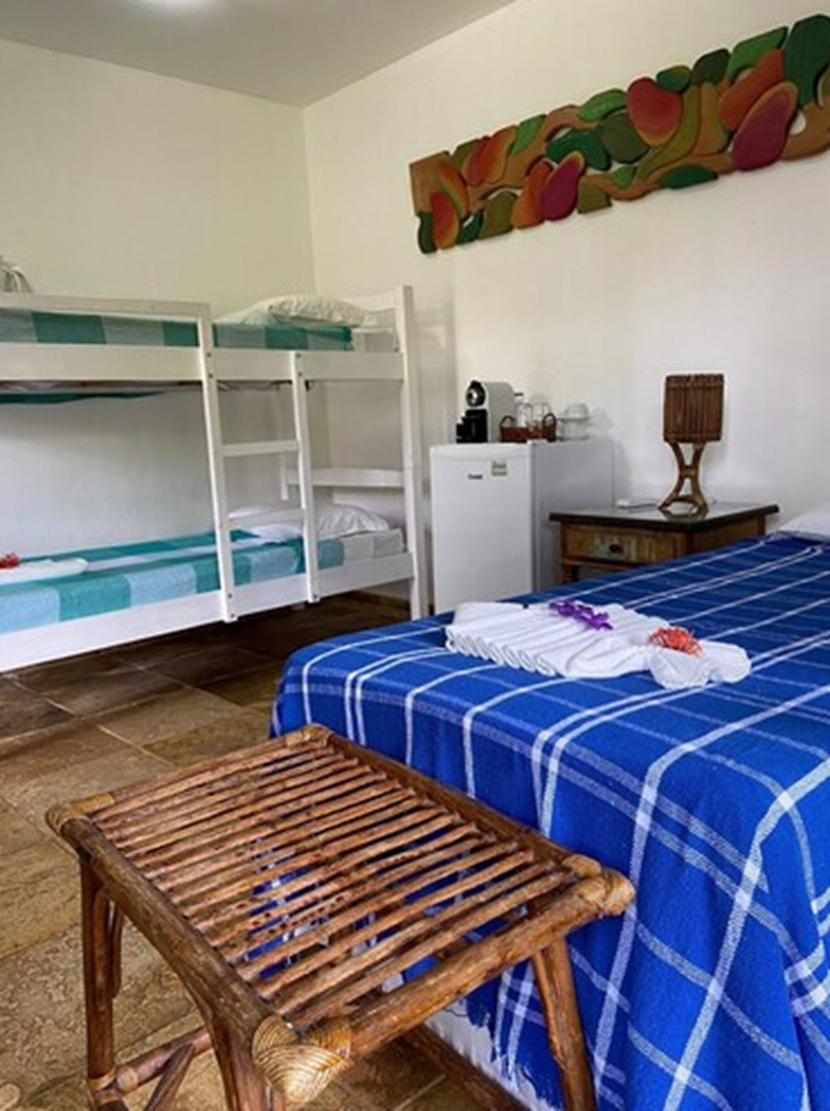 Un dormitorio con literas, una mesita pequeña, un escritorio con lámpara y un colorido adorno en la pared.