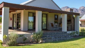 Una casa moderna con un porche cubierto, un comedor y una chimenea de ladrillo.