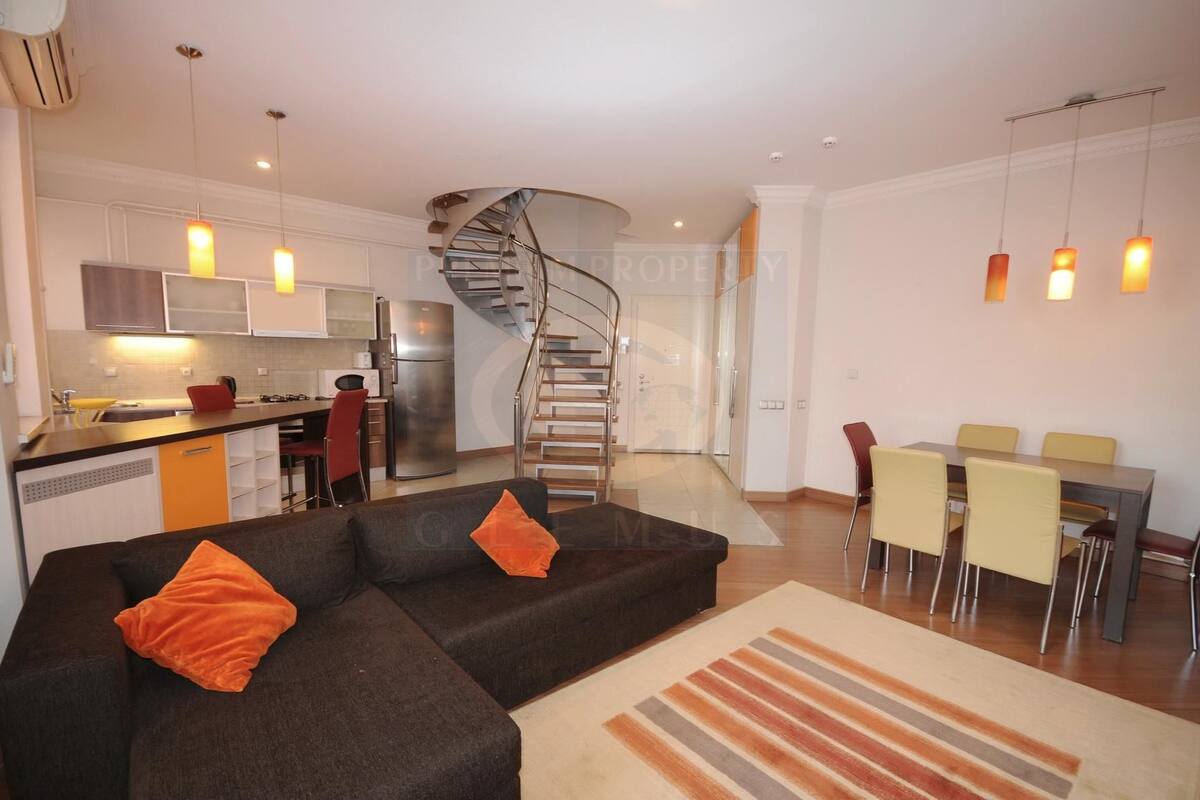 A modern apartment with a kitchen, dining area, and living room.