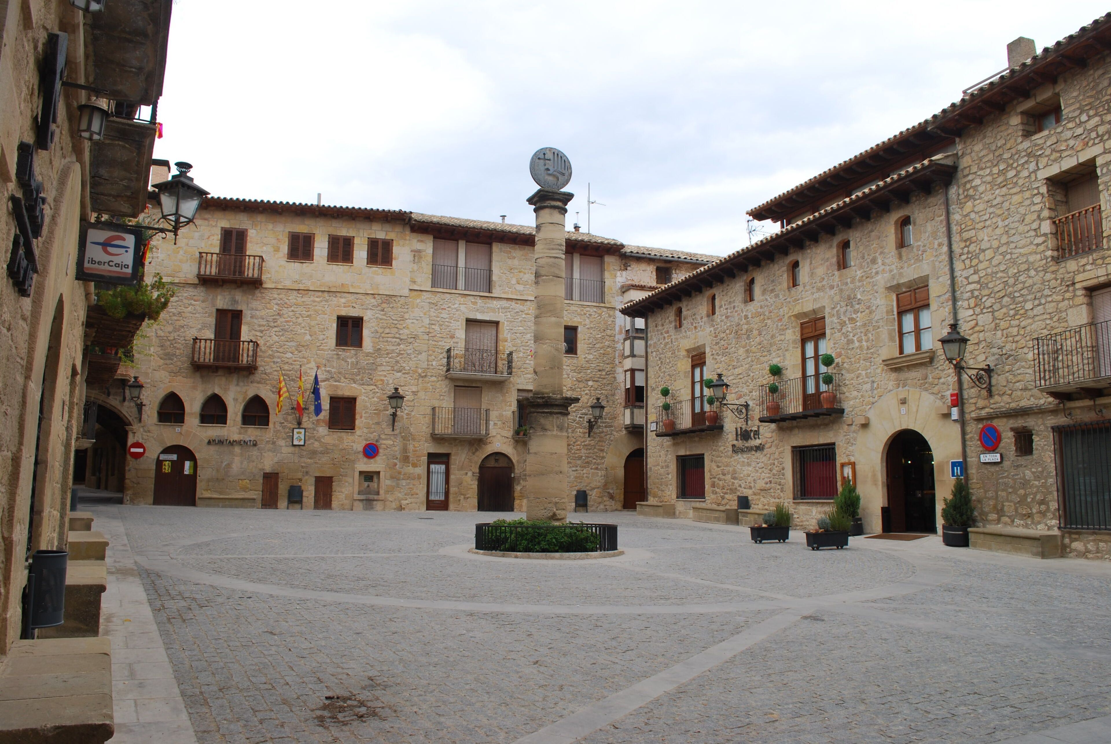 Un edificio storico in pietra con numerosi balconi, un cortile centrale e una torre dell'orologio.