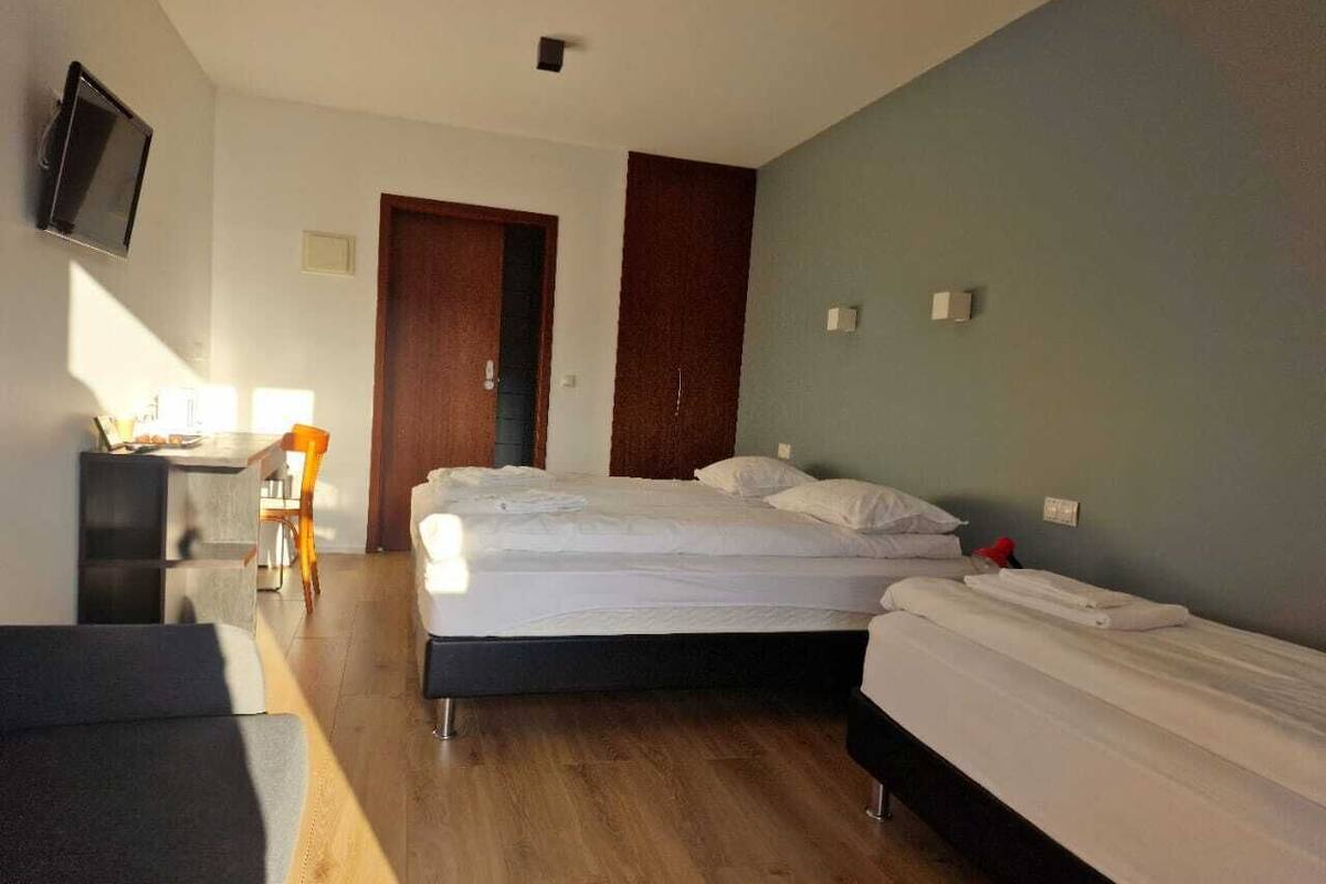A room with a bed, a desk, and a chair.