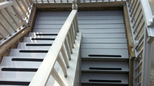 A staircase with white railings and a metal handrail. - East Street Inn & Suites Tipton (Tipton)