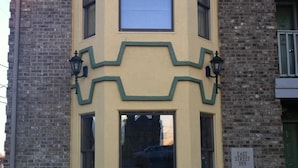 A corner building with a unique architectural design, featuring a large window and a sign indicating it is the East Street Inn. - East Street Inn & Suites Tipton (Tipton)
