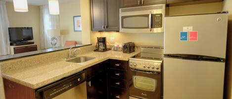 A modern kitchen with stainless steel appliances, a dishwasher, and a coffee maker.