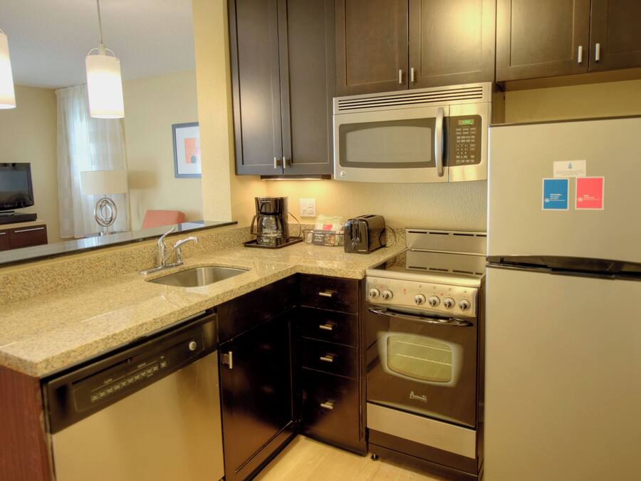 A modern kitchen with stainless steel appliances, a dishwasher, and a coffee maker.