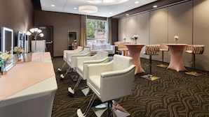 Une chambre d’hôtel moderne dotée d’un long comptoir de réception, de plusieurs espaces salon et d’une grande fenêtre donnant sur l’extérieur.