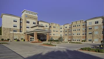 A multi-story hotel with a central entrance, multiple floors, and a stone facade.