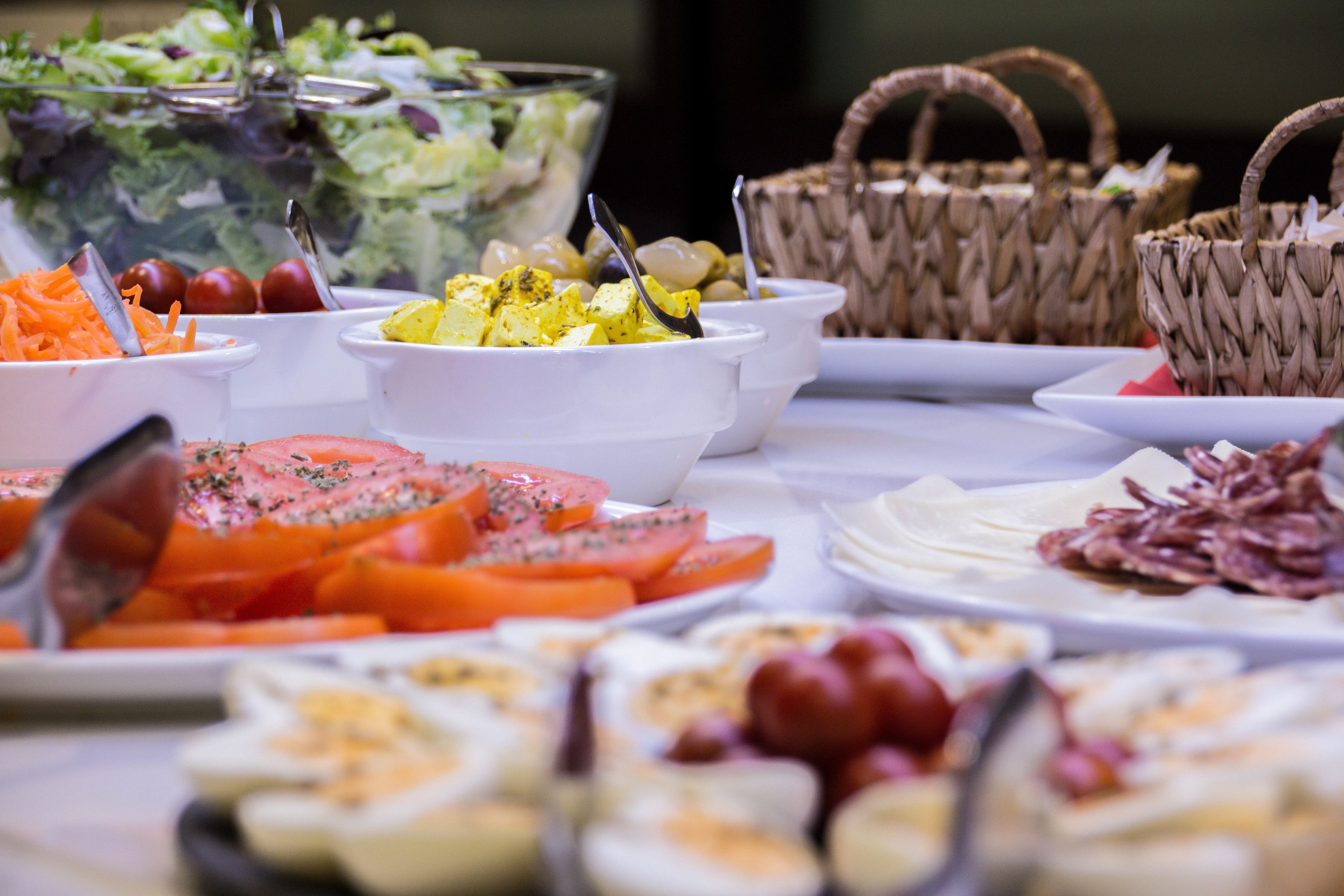 A buffet with various food items including salads, fruits, and appetizers.