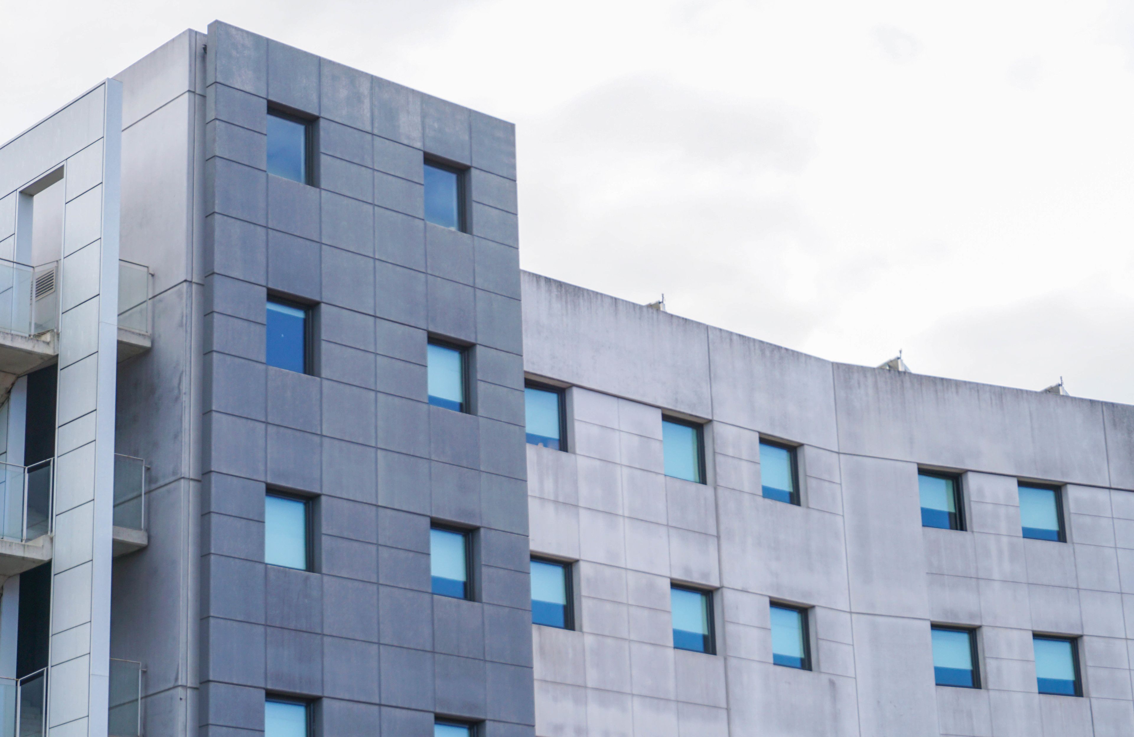 Un edificio moderno con una fachada plana y una rejilla de ventanas.