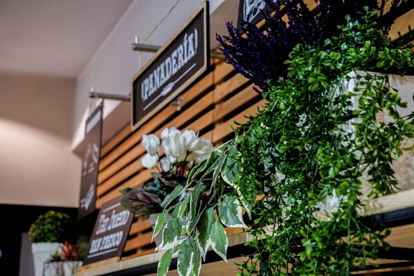 A wooden shelf with various plants and a sign that reads "PANADERIA". - ibis Girona Costa Brava (Girona)