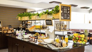 Una barra de desayuno con diferentes alimentos, un letrero que dice "HAZLO A TU GUSTO" y una cesta de frutas.