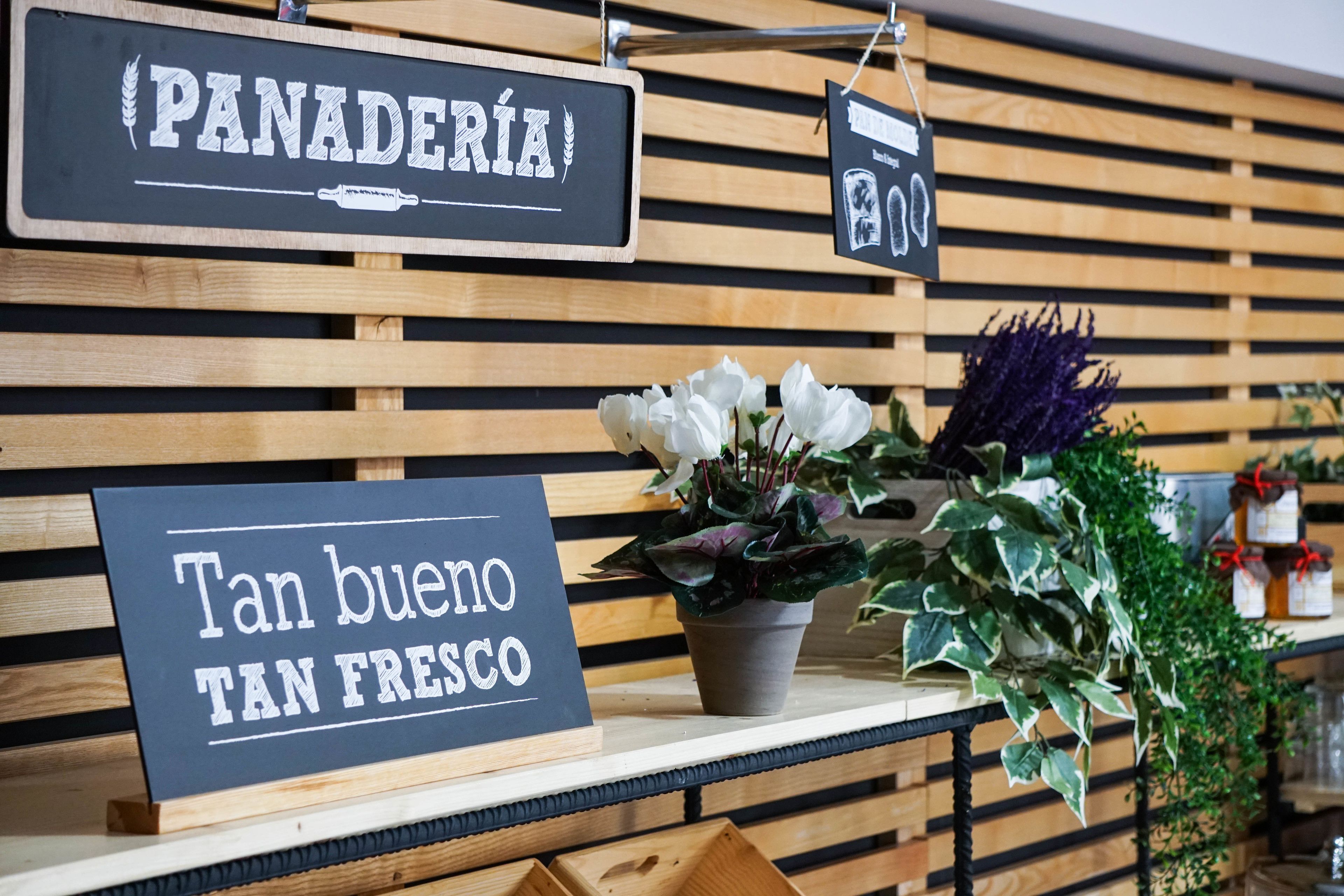 Señal con la palabra 'PANADERÍA' y el texto 'Tan bueno TAN FRESCO' en un café.