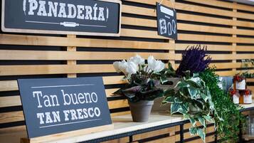 Señal con la palabra 'PANADERÍA' y el texto 'Tan bueno TAN FRESCO' en un café.