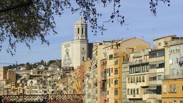 Un paisaje urbano histórico con una torre destacada, edificios que se reflejan y un río tranquilo.