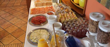 A buffet table with various food items and beverages.