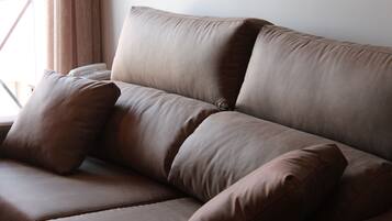 A brown leather sofa with two cushions.