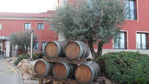Wooden wine barrels stacked on a wooden stand outdoors. - El Tollo Hotel (Utiel)