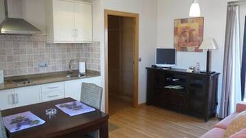 Un espacio habitable compacto con comedor, kitchenette y televisor.