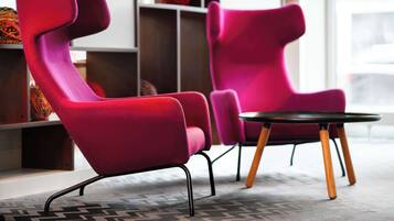 A modern interior with two vibrant red chairs and a small round table.