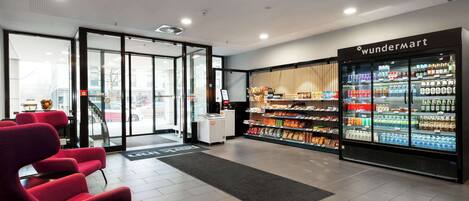A modern interior with a reception area, a refrigerated section labeled 'WunderMart', and a seating area with red chairs.