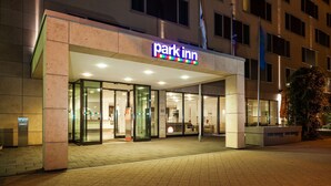 A hotel entrance with a 'Park Inn' sign, glass doors, and a reception desk. - Park Inn by Radisson Frankfurt Airport Hotel (Frankfurt)
