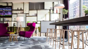 A modern interior with vibrant purple chairs, a round table, and a patterned carpet. - Park Inn by Radisson Frankfurt Airport Hotel (Frankfurt)