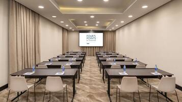A conference room with a large screen displaying "FOUR POINTS BY SHERATON LAGOS".