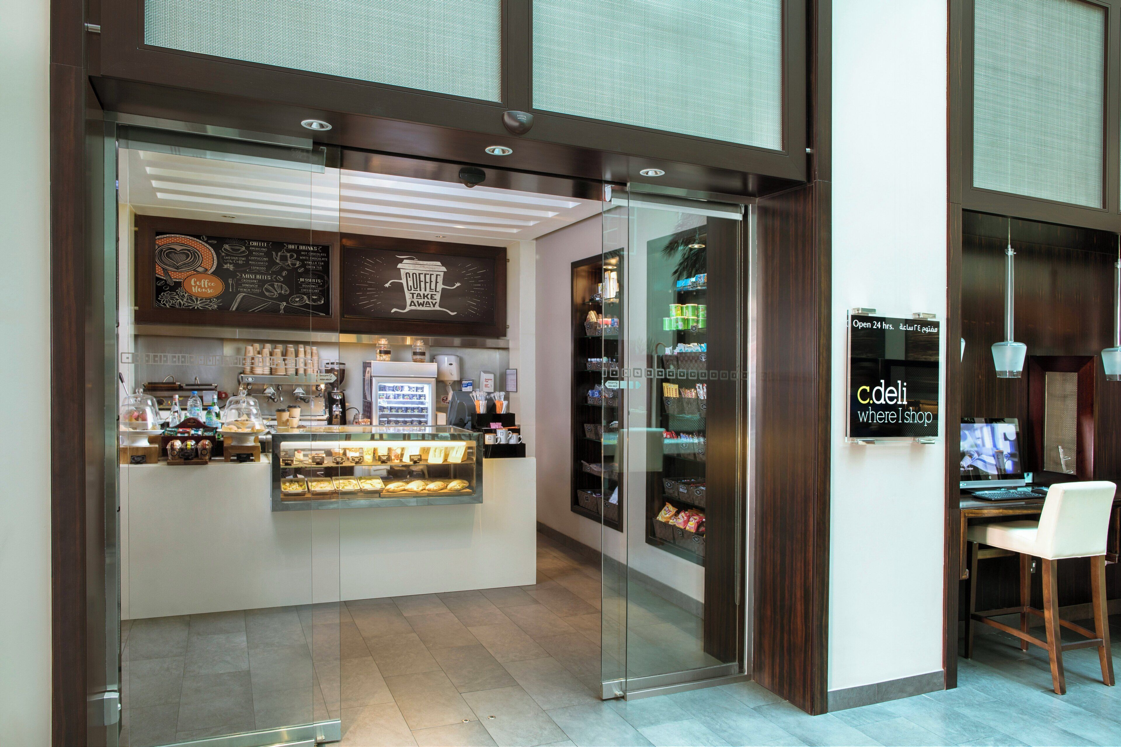 Un café avec une façade vitrée, une machine à café et un tableau affichant le menu.