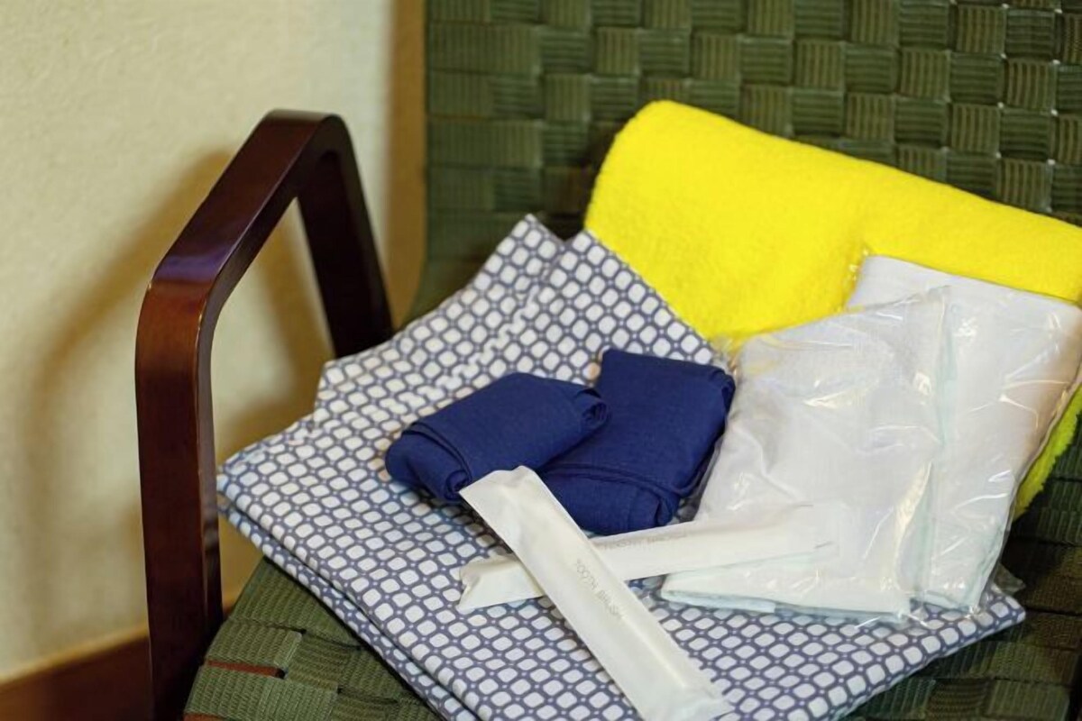 Une chaise avec un coussin à motifs, un oreiller jaune et un sac en plastique.