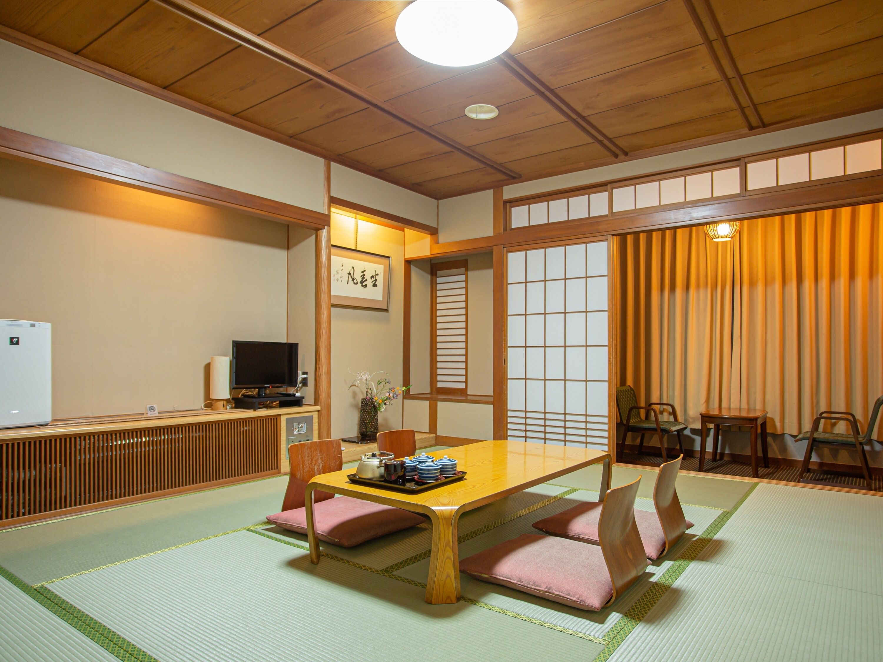 A traditional Japanese-style room with tatami flooring, a low table, and shoji screens.
