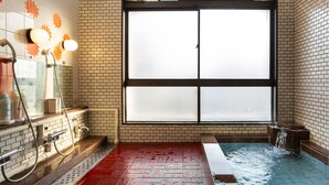 Een badkamer met een groot raam, een douchegedeelte en een bad.