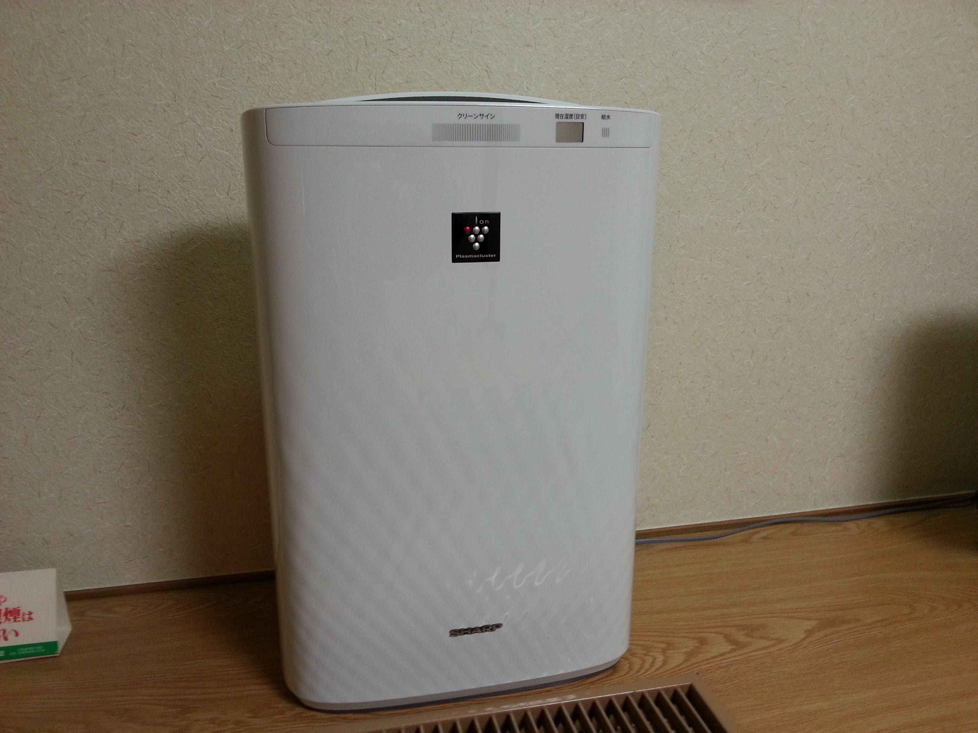 A white, cylindrical device with a digital display and a small logo on the top.