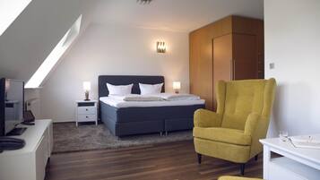 Une chambre à coucher moderne, comprenant un lit, des tables de chevet, un bureau, une chaise et une armoire.
