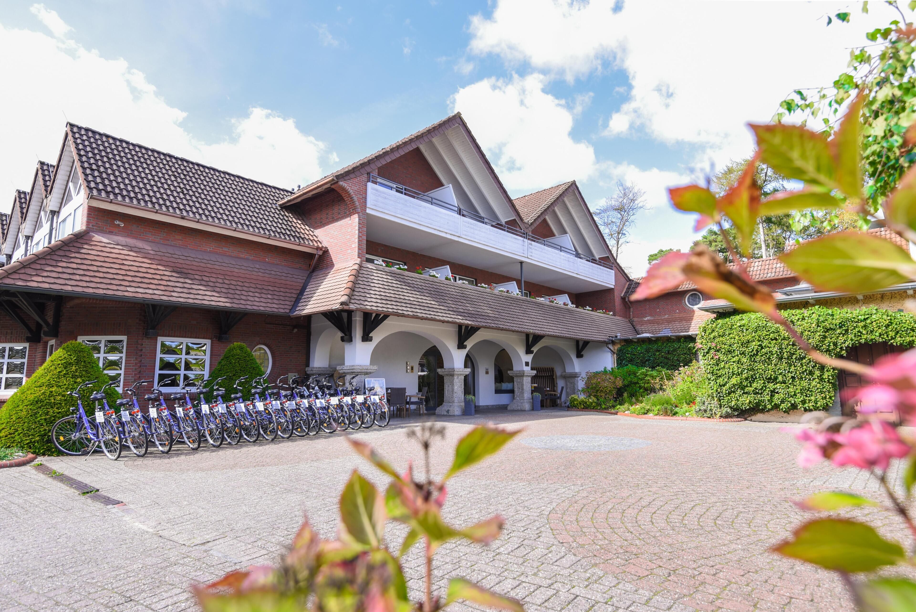 A building with a tiled roof, a covered entrance, and a row of bicycles parked outside.