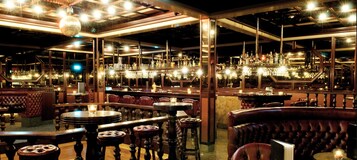 Eine Bar mit mehreren Sitzgelegenheiten, Tischen und einer Theke.