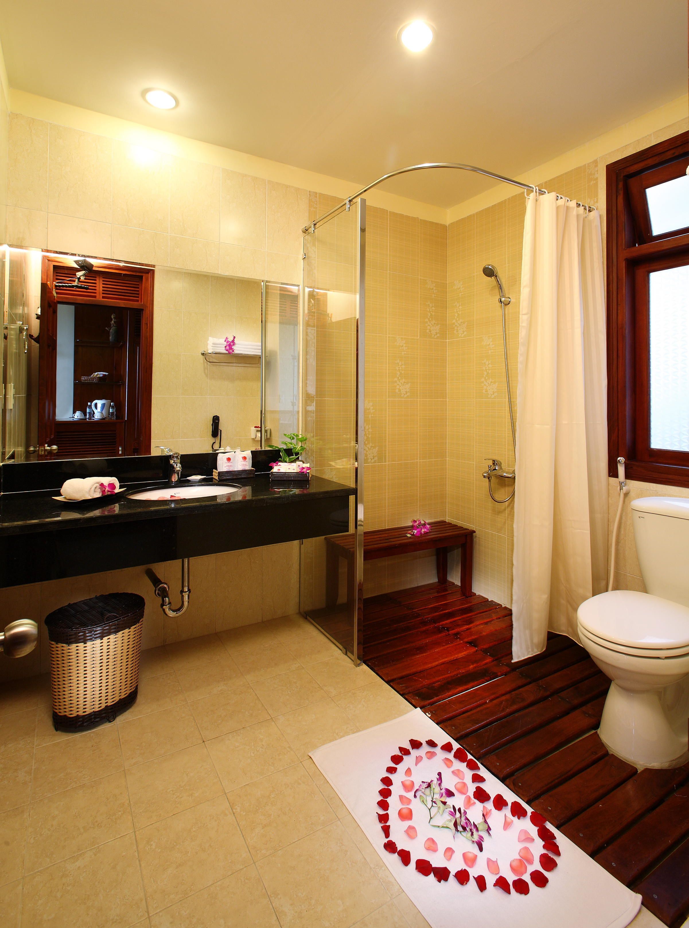 A bathroom with a shower, toilet, and sink.