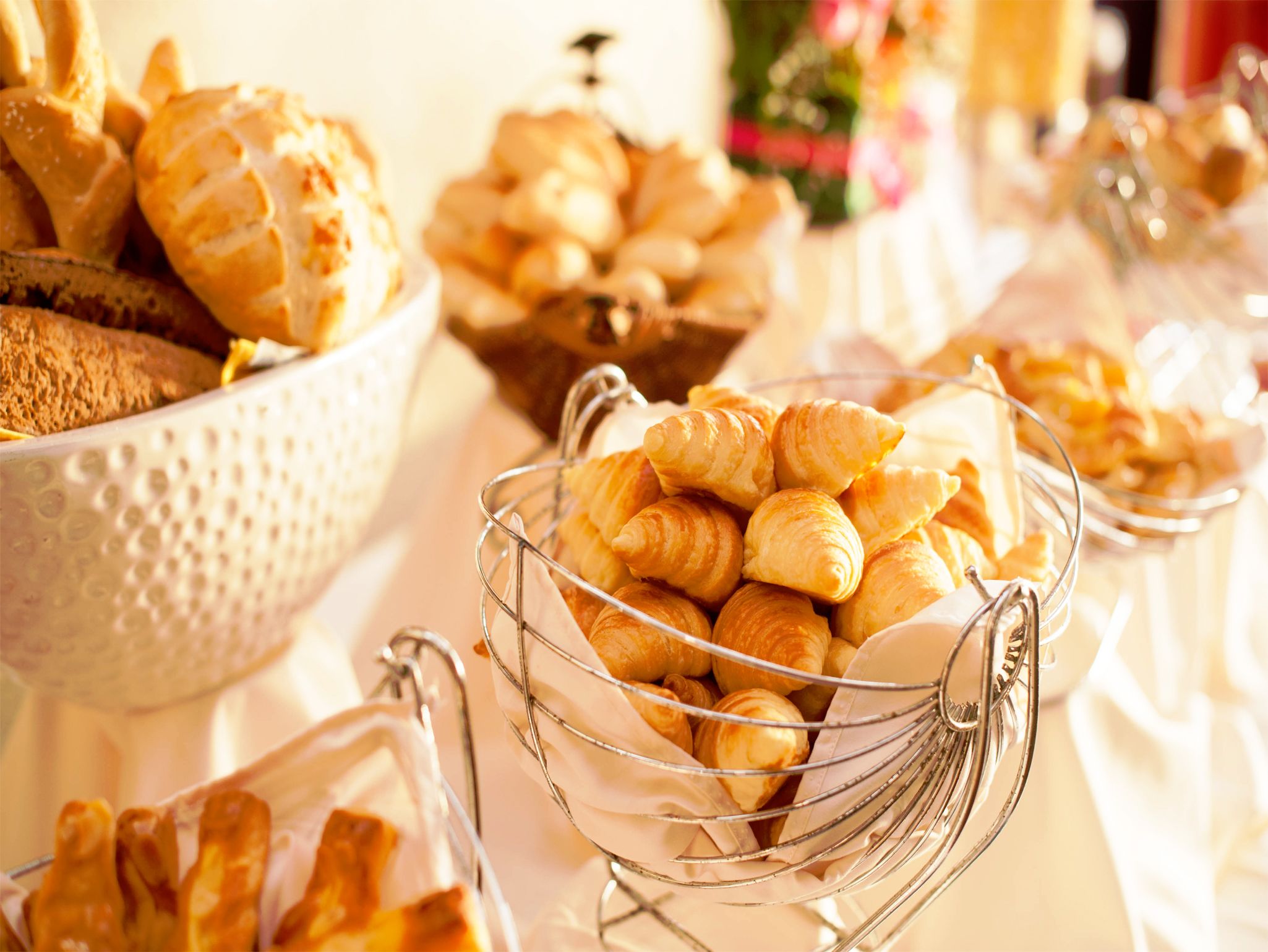Een buffet met verschillende gebakjes, waaronder croissants en brood.