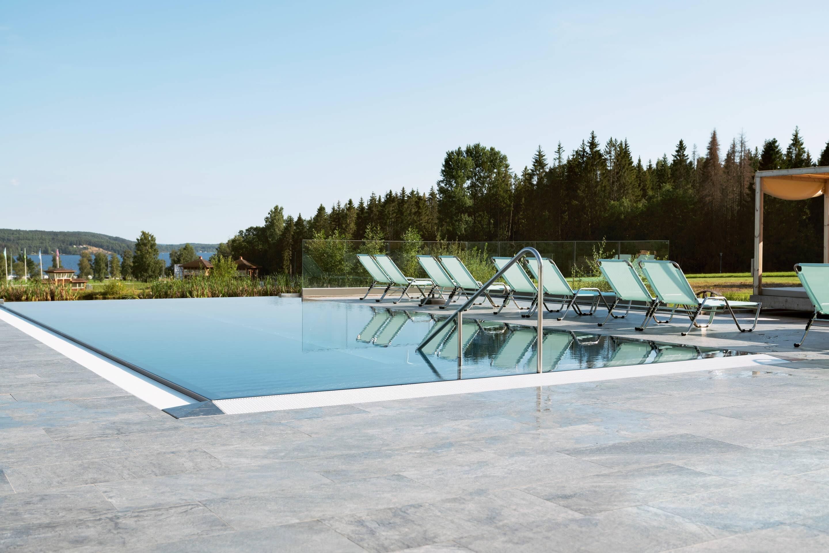 A swimming pool with lounge chairs and a gazebo.