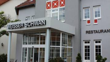 A building with a sign that reads "WEISSER SCHWAN" and "RESTAURANT" indicating it is a hotel with a restaurant.