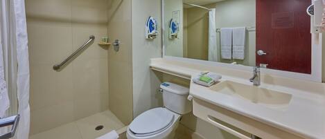 A bathroom with a shower, toilet, and sink.