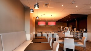 A modern restaurant interior with booths, tables, and pendant lighting. - Hotel Expo (Brussels)