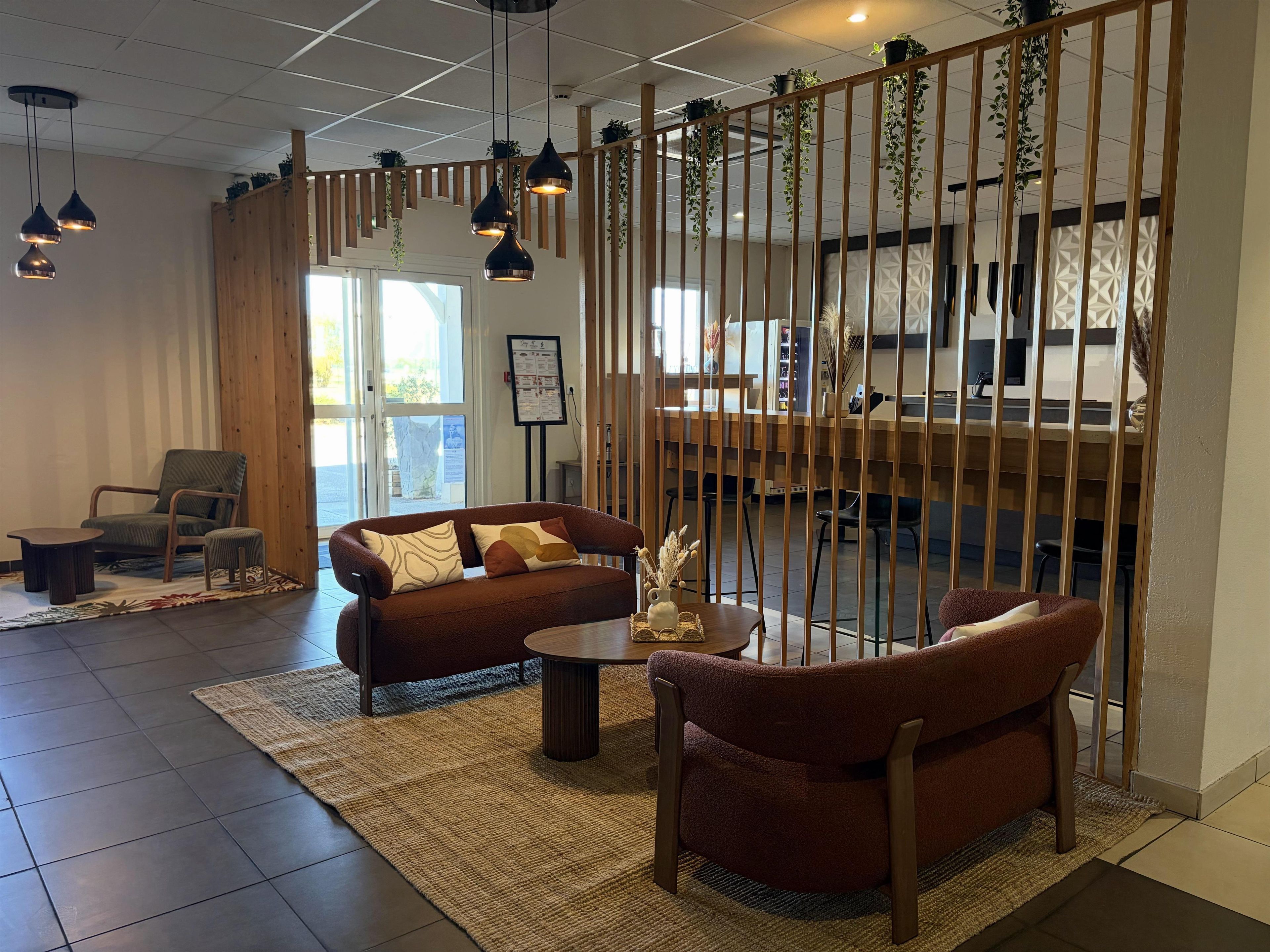 A modern interior with a sofa, chairs, a coffee table, and hanging plants.