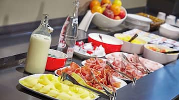 Un buffet con diverse pietanze, tra cui formaggi, salumi e frutta.