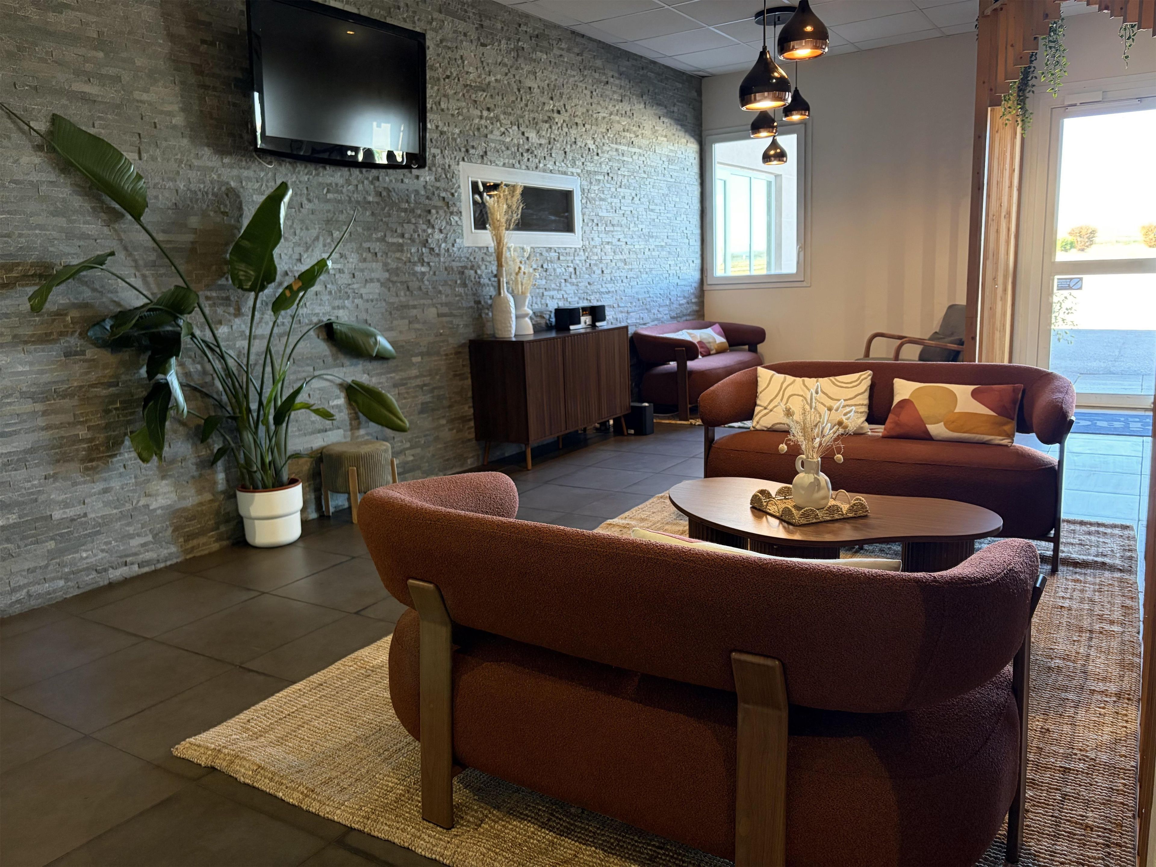 Un salon moderne avec un canapé, une table basse et des plantes en pot.