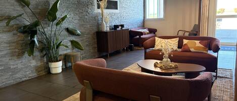 Un salon moderne avec un canapé, une table basse et des plantes en pot.