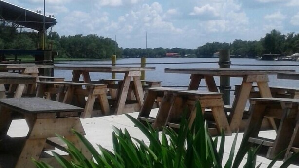 A lakeside picnic area with wooden benches and a lamp post. - Astor Bridge Marina & Motel (Astor)