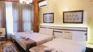 Quarto de hotel com duas camas, teto de madeira e tapete estampado.