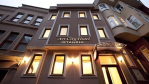 Hotel Art City em Istambul, com estilo arquitetônico clássico, apresentando diversas janelas e uma entrada imponente.