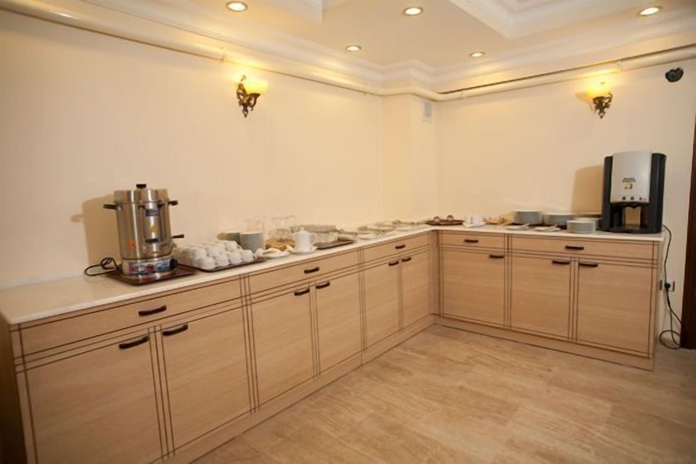 Una cucina con mobili in legno, una macchina da caffè e un bollitore.
