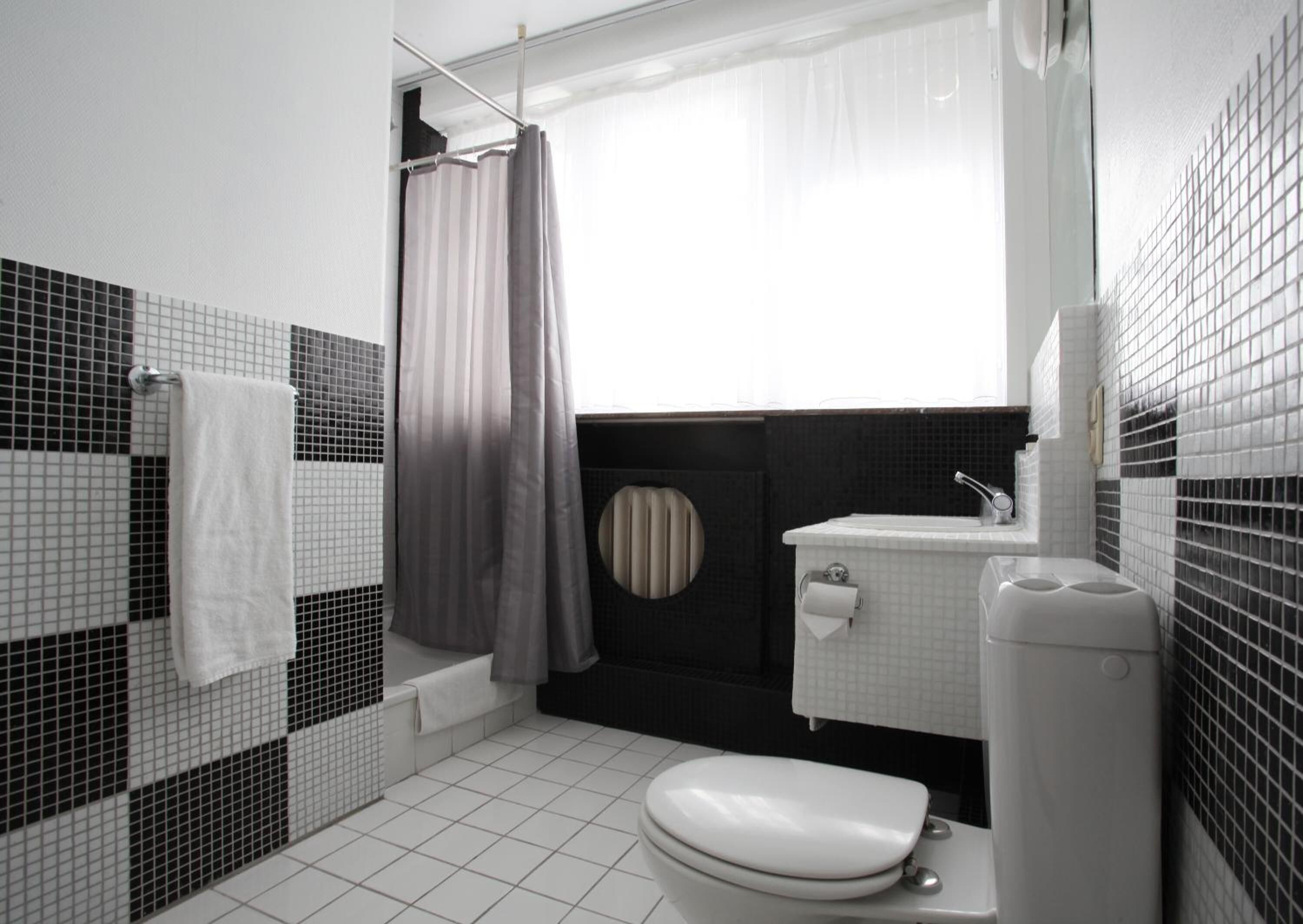 Un baño con inodoro, lavamanos y bañera.